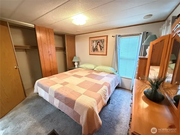 a bedroom with a bed and a mirror on the dresser