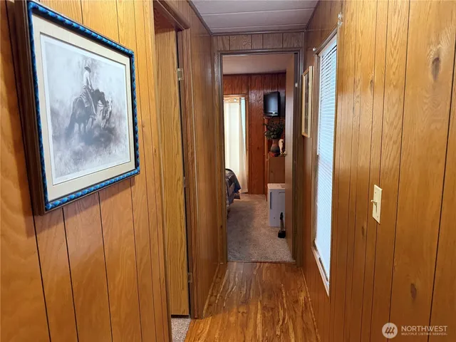 a view of a hallway with wooden floor and closet