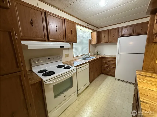 a kitchen with a stove a refrigerator and a sink