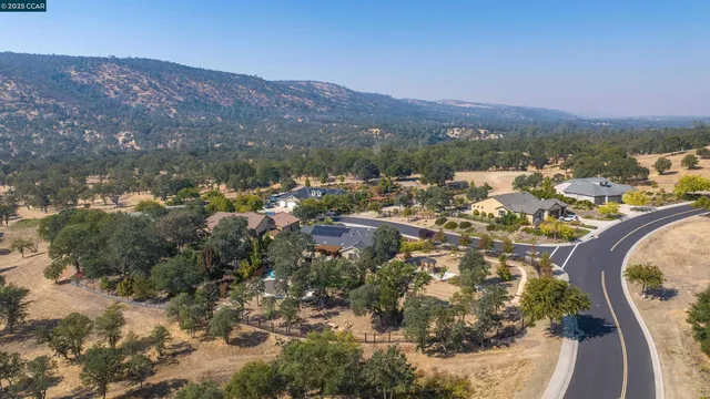 an aerial view of a house with a mountain