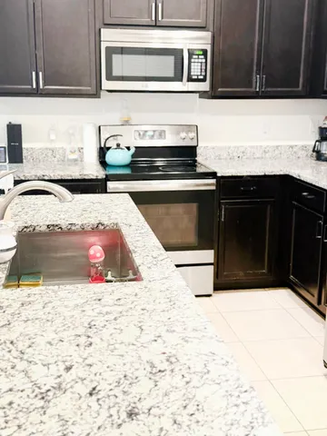 a kitchen with granite countertop a stove and a sink