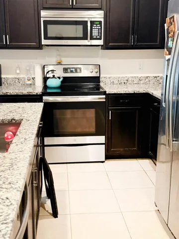 a kitchen with granite countertop a stove and a microwave
