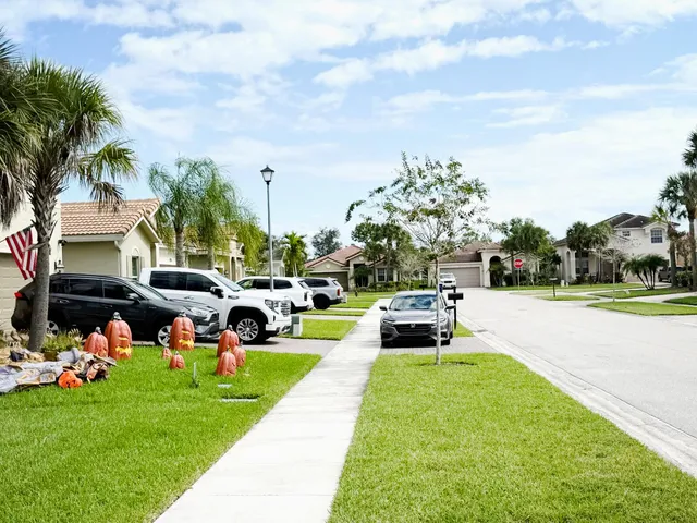 a view of a swimming pool with lawn chairs and a big yard