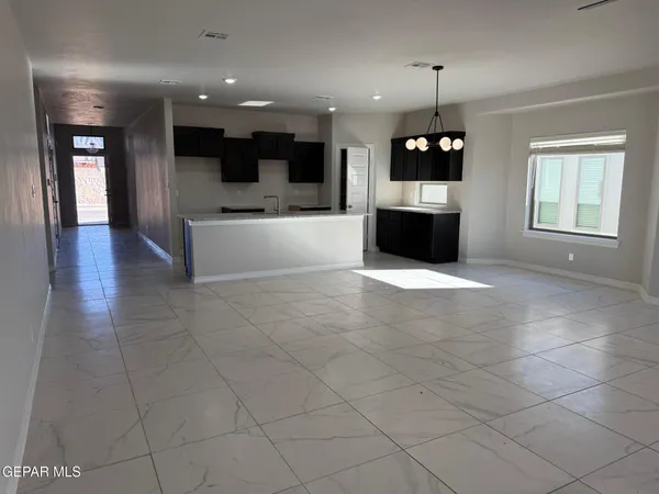 a view of an empty room with a ceiling fan and window