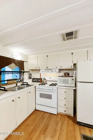 a kitchen with granite countertop cabinets and white appliances