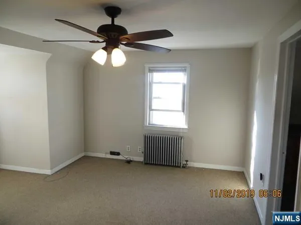 an empty room with a window and a fan