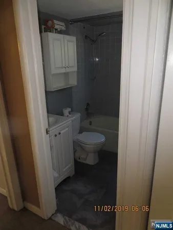 a bathroom with a granite countertop toilet and a sink