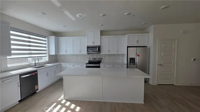 a kitchen with a refrigerator and a stove top oven