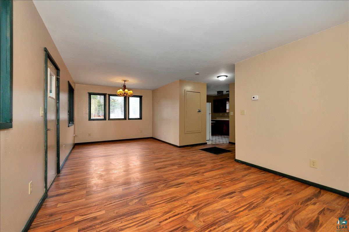 6355 Stoney Brook Road Alborn, MN 55702 - Photo 3 of 18 Empty room featuring wood finished floors and suspended lighting