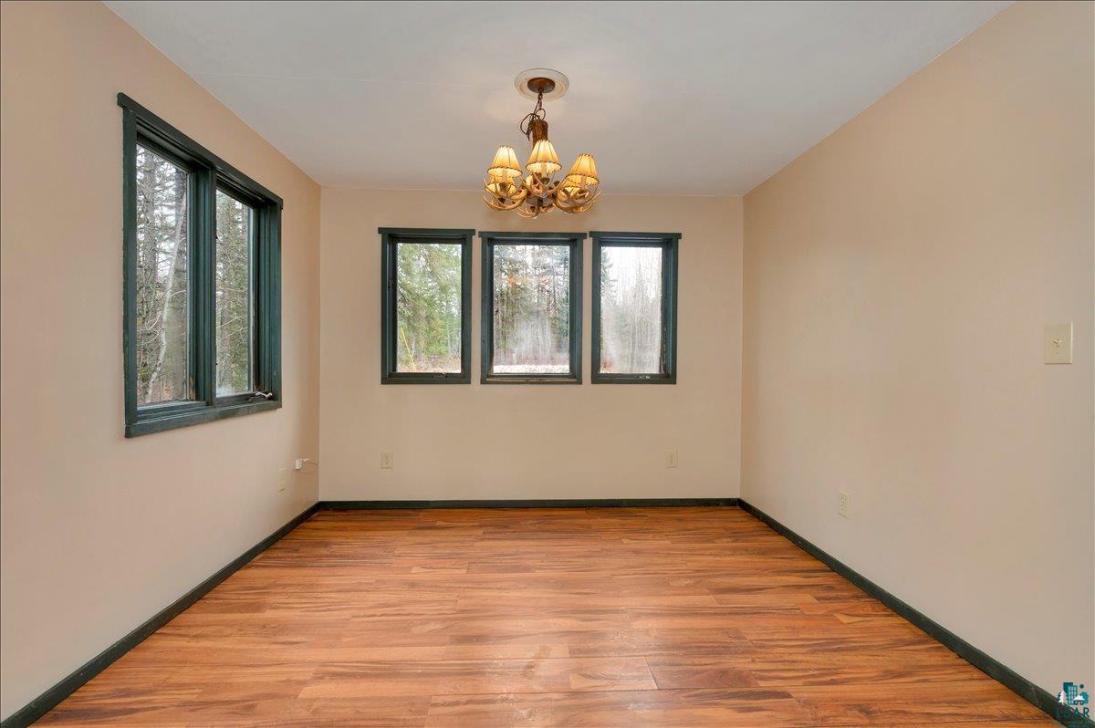 6355 Stoney Brook Road Alborn, MN 55702 - Photo 4 of 18 Empty room featuring light wood-type flooring and suspended lighting