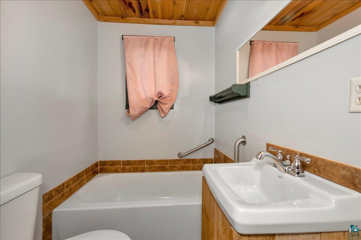 6355 Stoney Brook Road Alborn, MN 55702 - Photo 7 of 18 Full bathroom featuring wooden ceiling, a bath, and vanity