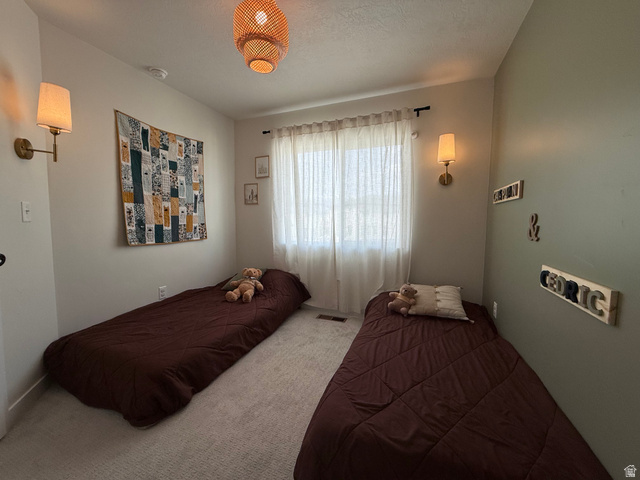 774 West 480 South American Fork, UT 84003 - Photo 67 of 76 Carpeted room featuring a window with sheer curtains, two wall-mounted sconces, and a woven ceiling light fixture