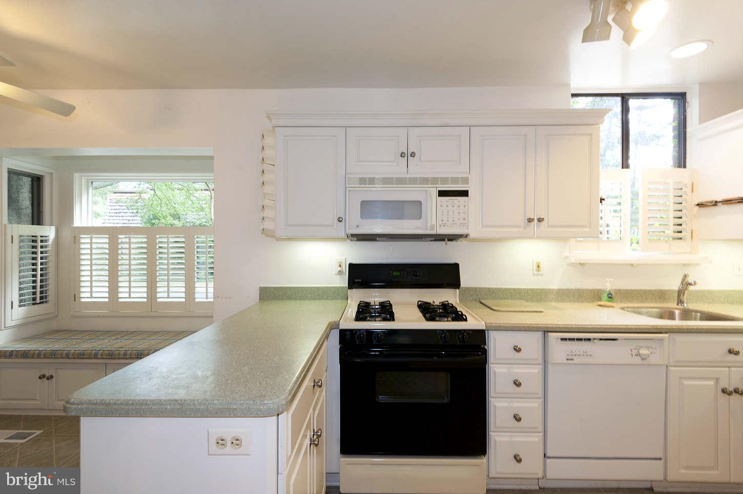 7964 Inverness Ridge Road Potomac, MD 20854 - Photo 15 of 28 a kitchen with granite countertop white cabinets sink and window