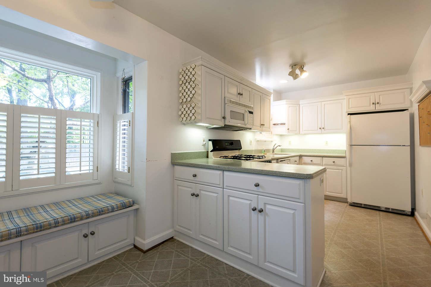7964 Inverness Ridge Road Potomac, MD 20854 - Photo 16 of 28 a kitchen with granite countertop white cabinets and white appliances