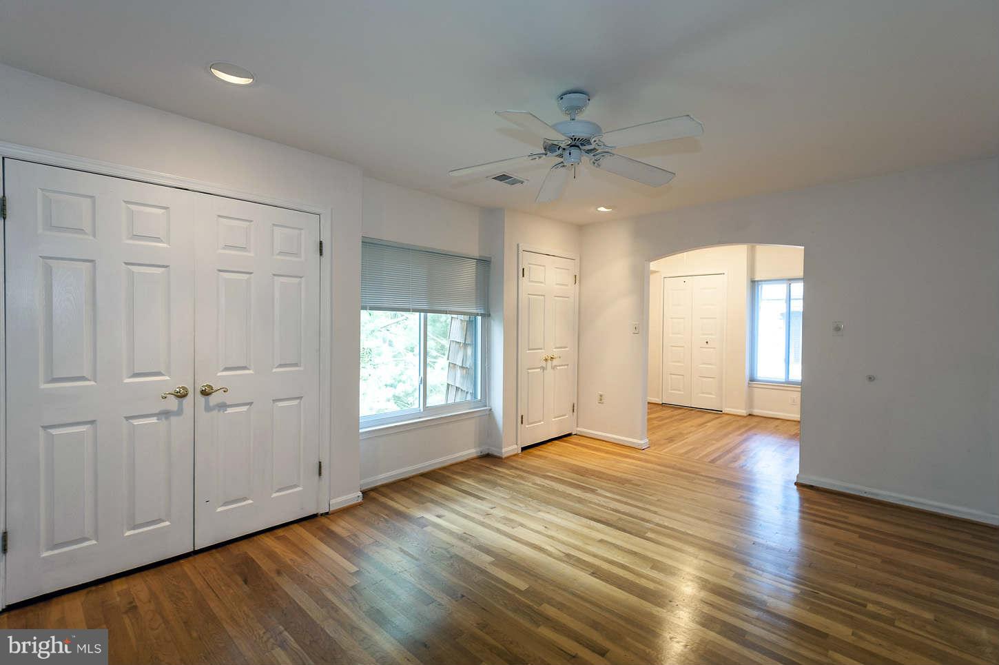 7964 Inverness Ridge Road Potomac, MD 20854 - Photo 22 of 28 an empty room with wooden floor fan and windows