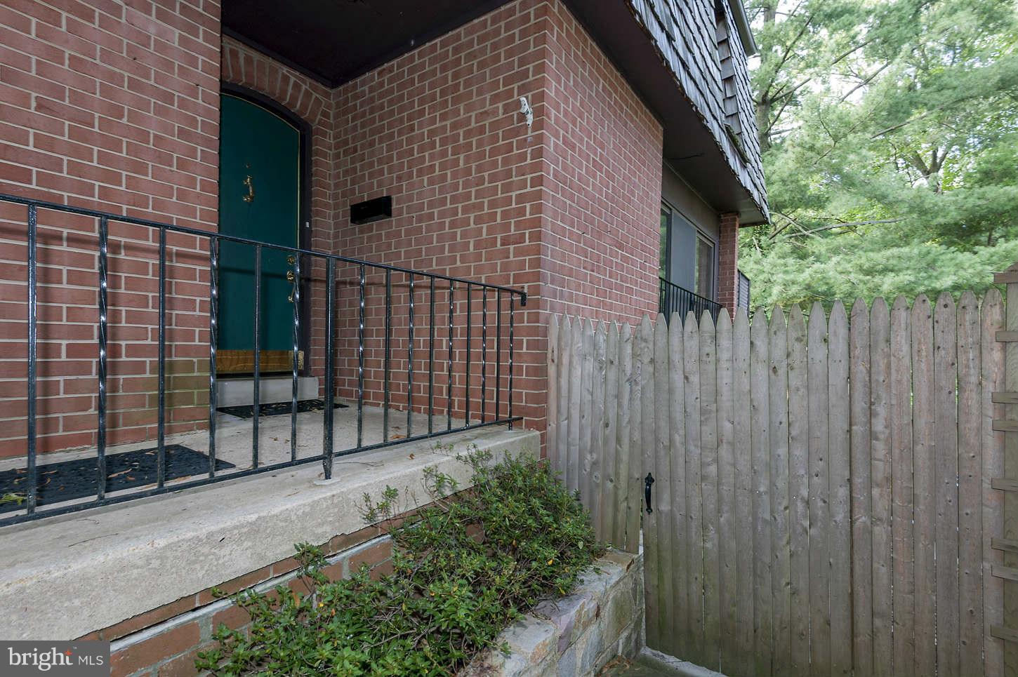7964 Inverness Ridge Road Potomac, MD 20854 - Photo 6 of 28 a brick house with a small yard and wooden fence