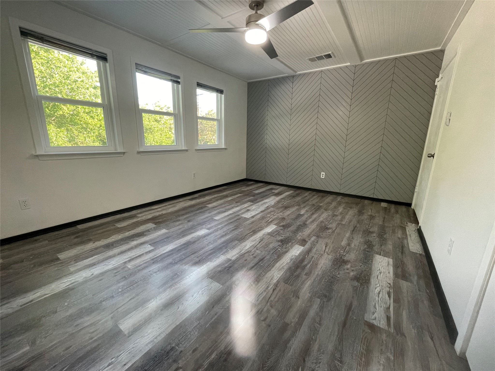 5802 Longhorn Landing Austin, TX 78734 - Photo 21 of 38 Unfurnished room with ceiling fan, dark wood-style floors, an accent wall, and wood walls