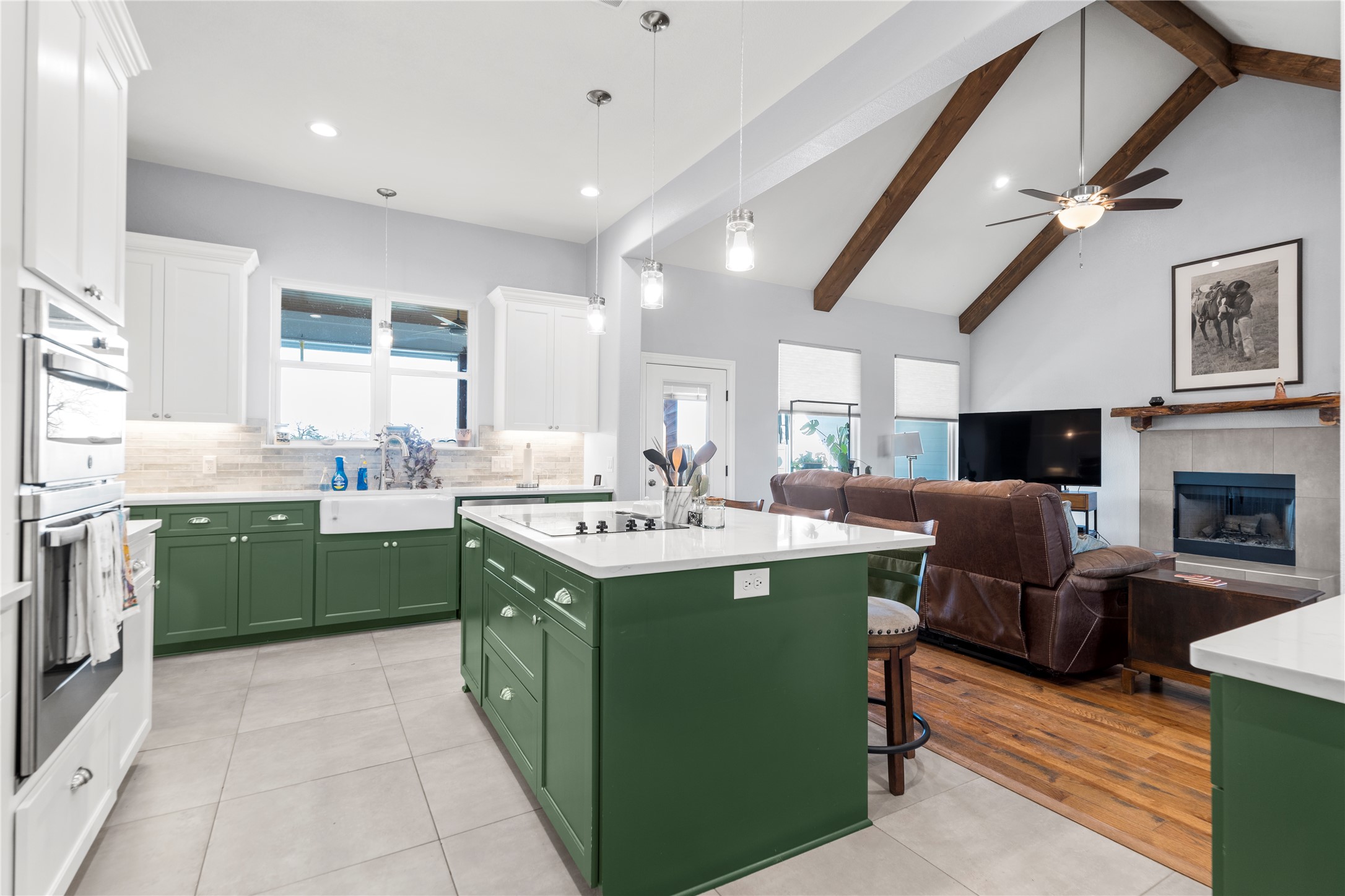 1434 Antioch Road Paige, TX 78659 - Photo 40 of 40 Dual tone kitchen featuring dual tone cabinets, a center island, open floor plan, light tile patterned floors, and a breakfast bar area