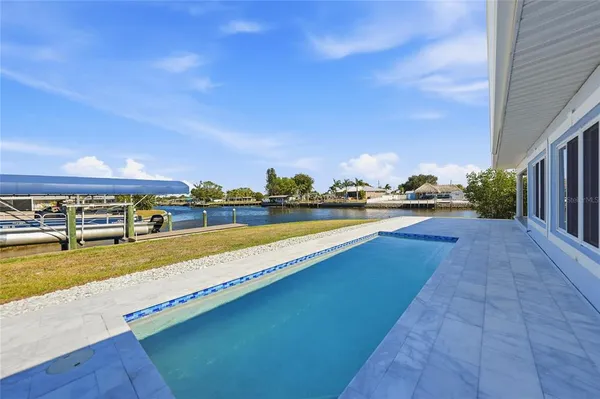 a view of swimming pool with outdoor seating and plants