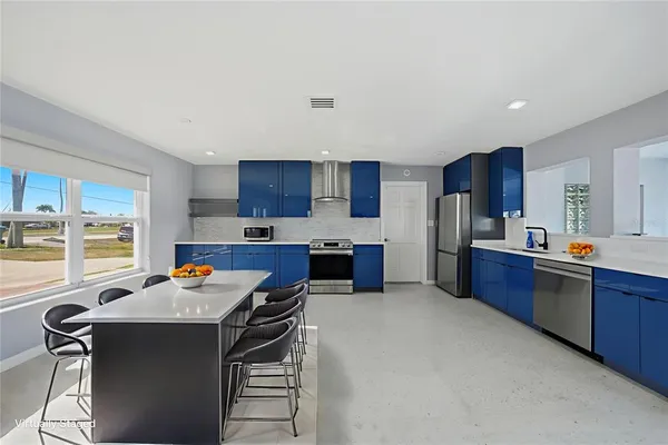 a kitchen with stainless steel appliances wooden cabinets granite counter tops a stove a sink dishwasher and a refrigerator with wooden cabinets