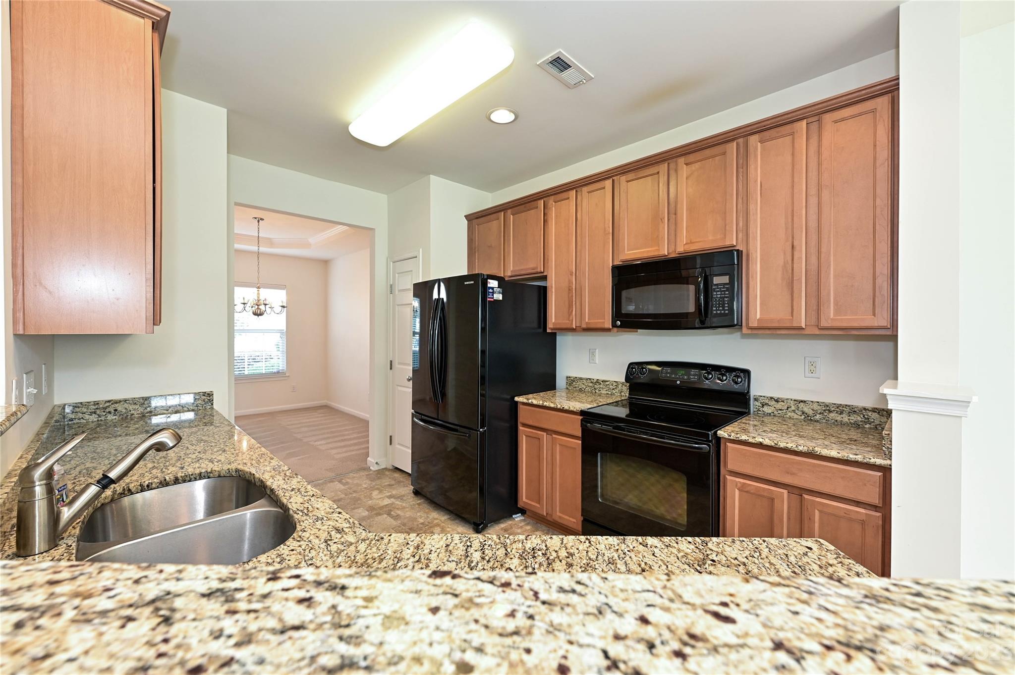530 White Springs Road, Unit 21 Fort Mill, SC 29708 - Photo 13 of 42 a kitchen with kitchen island granite countertop a sink stove and refrigerator