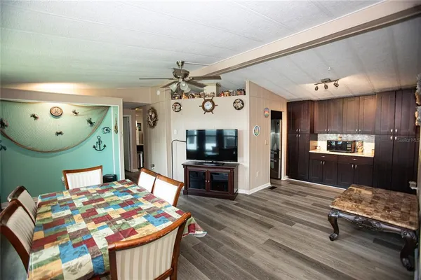a living room with kitchen island granite countertop furniture and a wooden floor