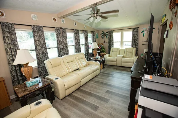 a living room with furniture flat screen tv and a large window