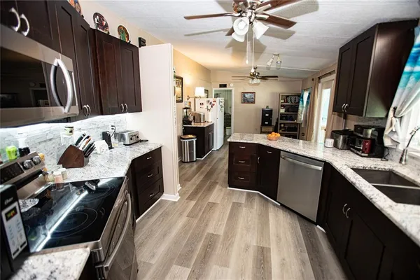 a kitchen with stainless steel appliances kitchen island granite countertop a sink stove and refrigerator