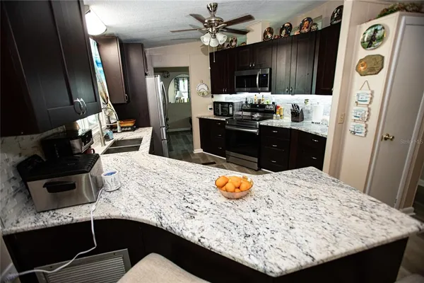 a kitchen with a sink a kitchen island a stove a refrigerator and cabinets
