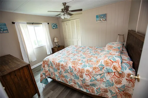 a bedroom with a bed and a mirror on the dresser