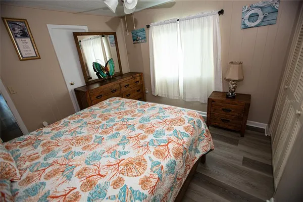 a bedroom with a bed and a mirror on dresser