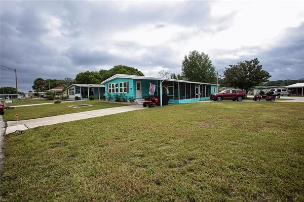a view of a house with a yard and sitting area