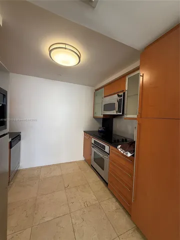a kitchen with granite countertop a stove and a refrigerator