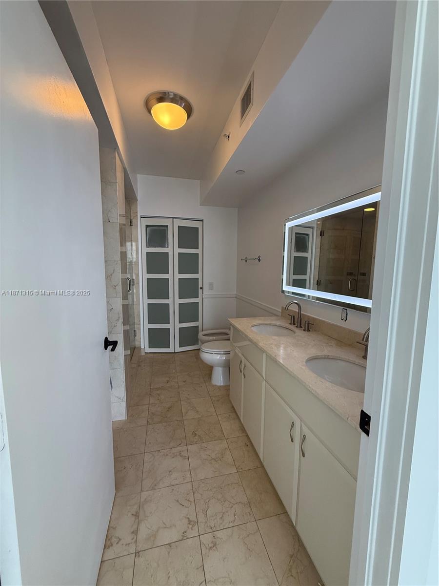 6365 Collins Avenue, Unit 904 Miami Beach, FL 33141 - Photo 20 of 35 a bathroom with a sink a toilet and a bathtub