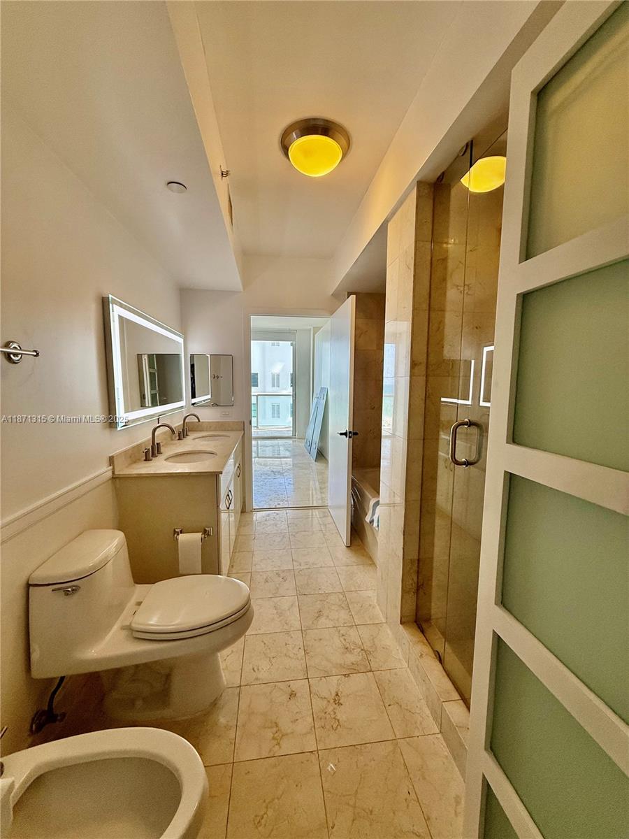 6365 Collins Avenue, Unit 904 Miami Beach, FL 33141 - Photo 23 of 35 a bathroom with a toilet and a shower