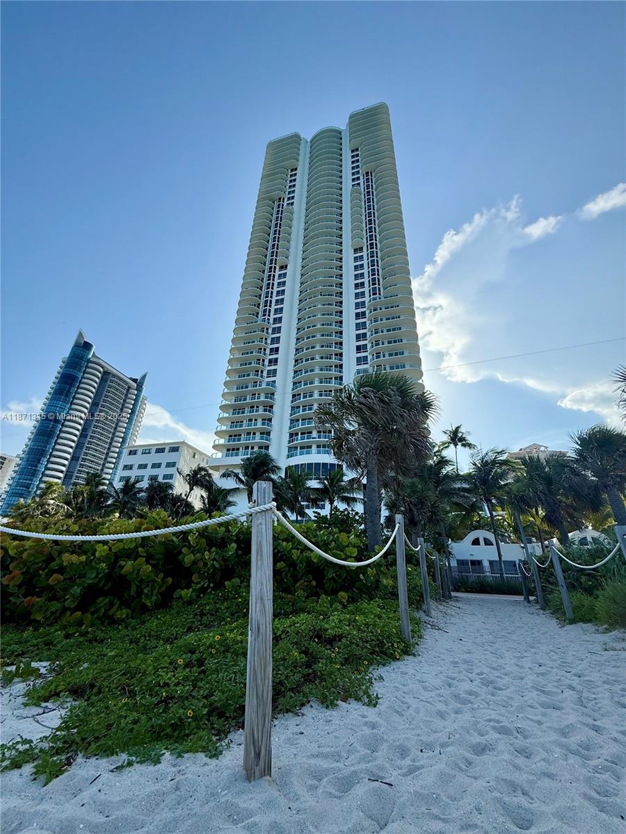 6365 Collins Avenue, Unit 904 Miami Beach, FL 33141 - Photo 31 of 35 a view of a multi story residential apartment building with yard and green space