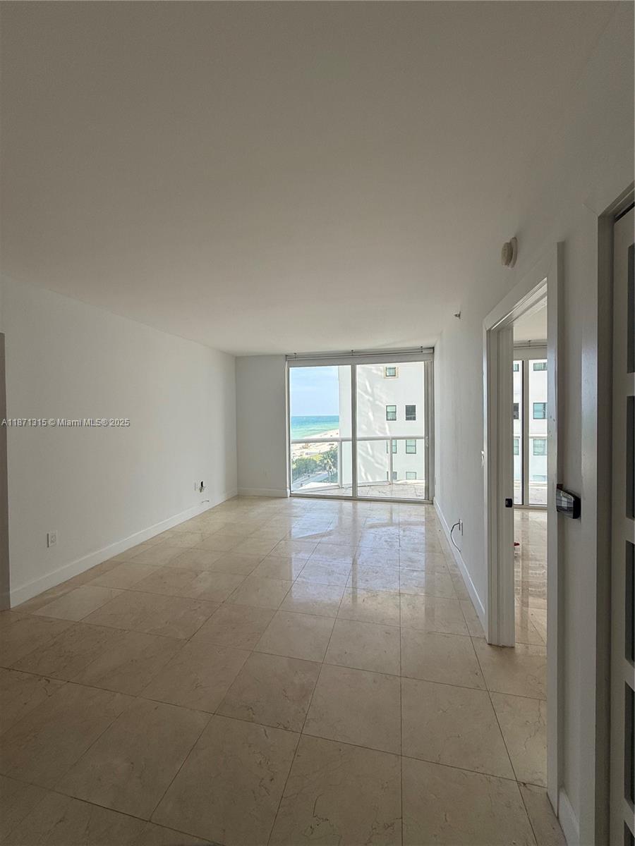 6365 Collins Avenue, Unit 904 Miami Beach, FL 33141 - Photo 8 of 35 an empty room with windows and cabinet