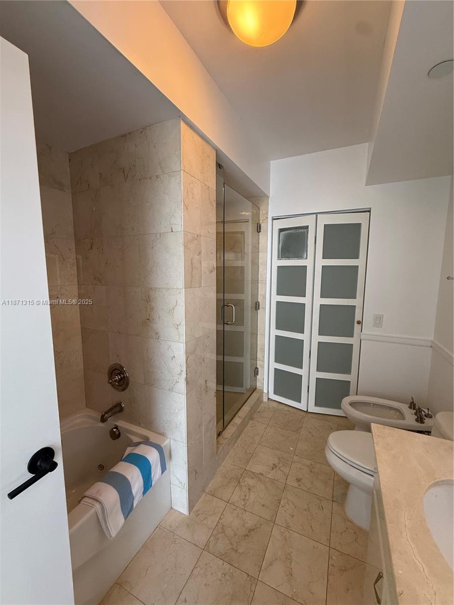 6365 Collins Avenue, Unit 904 Miami Beach, FL 33141 - Photo 10 of 35 a bathroom with a granite countertop sink a toilet and a bathtub