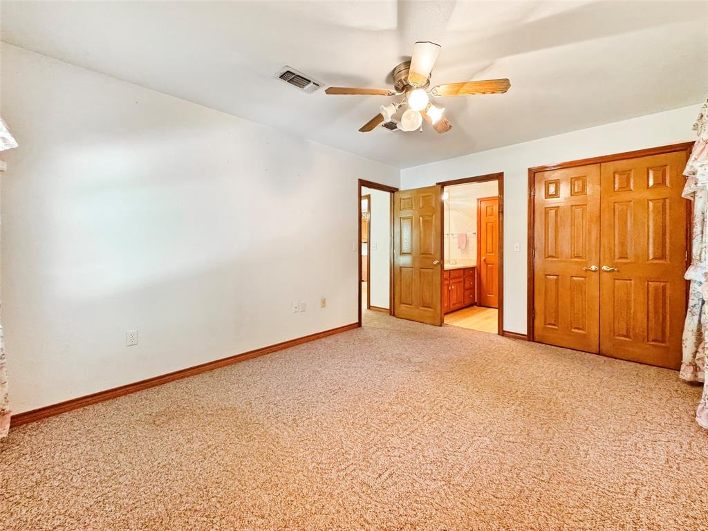 3870 County Road Arthur City, TX 75411 - Photo 26 of 39 Carpeted room with white walls, wood trim, and a ceiling fan with light fixture