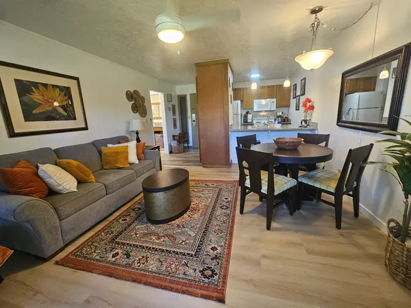 a living room with furniture a flat screen tv and a table