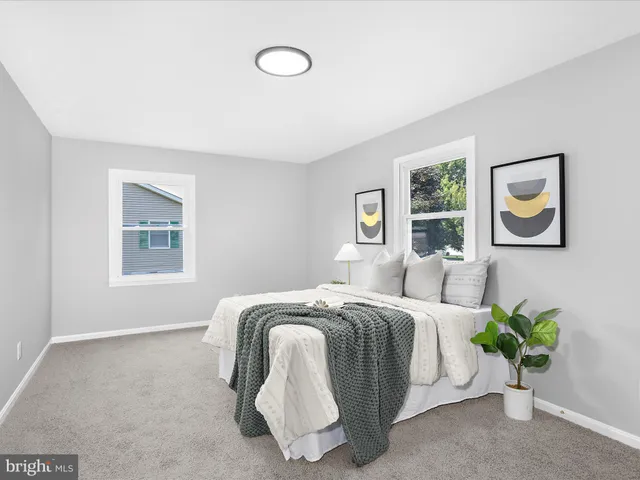 a bedroom with a bed and painting on the wall