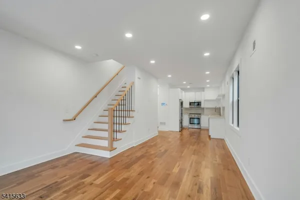 a view of kitchen and hall with wooden floor