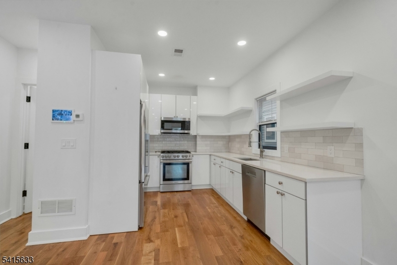 71 Mission Street, Unit 2 Montclair, NJ 07042 - Photo 4 of 25 a kitchen with stainless steel appliances a refrigerator a stove top oven and sink