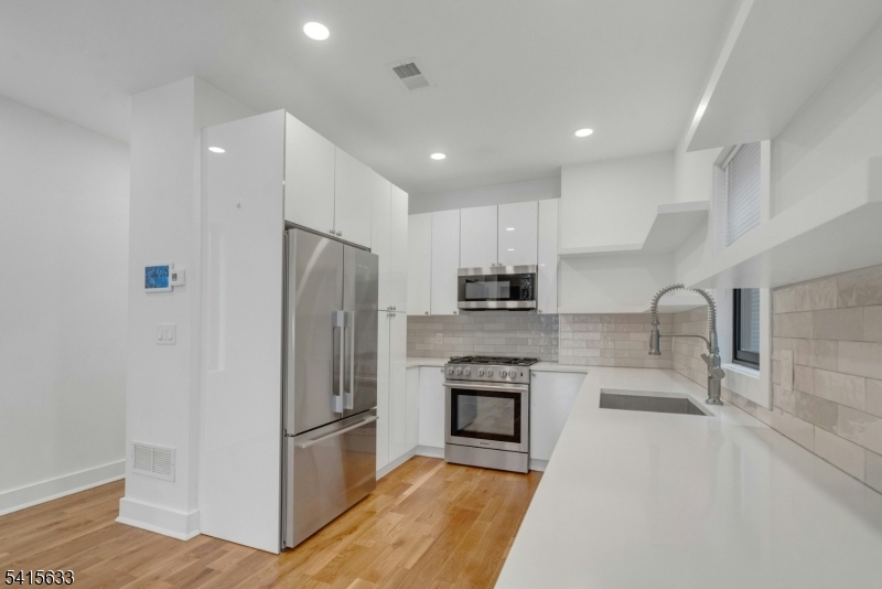 71 Mission Street, Unit 2 Montclair, NJ 07042 - Photo 5 of 25 a kitchen with stainless steel appliances granite countertop a refrigerator and a sink