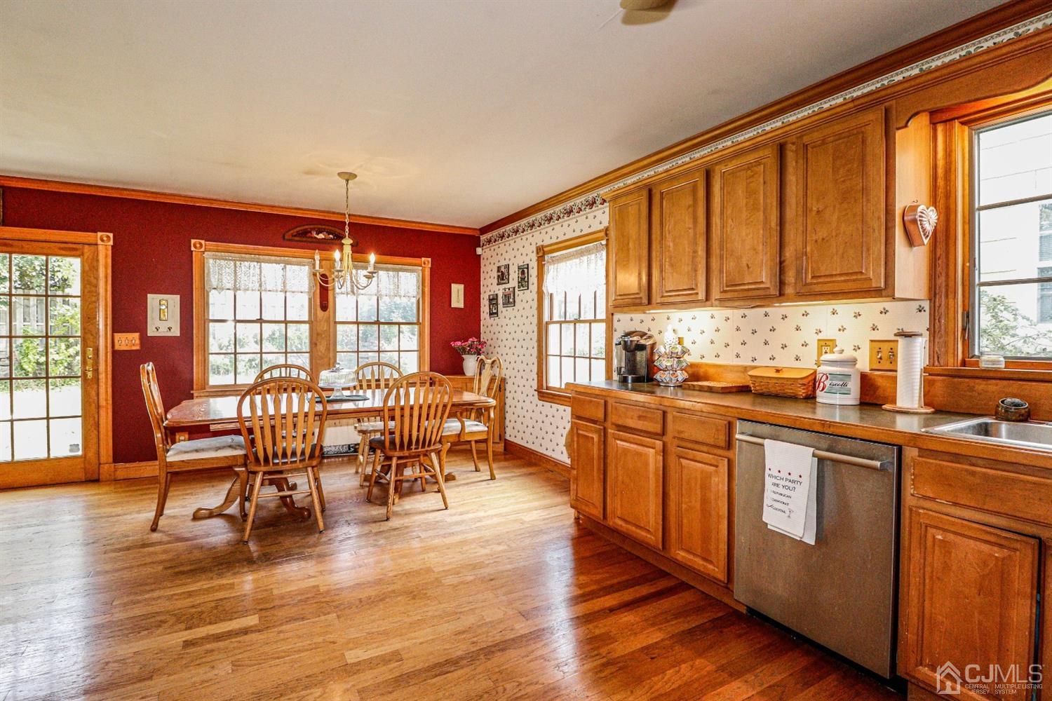 485 Whitewood Road Union, NJ 07083 - Photo 6 of 24 a kitchen with stainless steel appliances granite countertop a stove top oven a sink a dining table and chairs with wooden floor