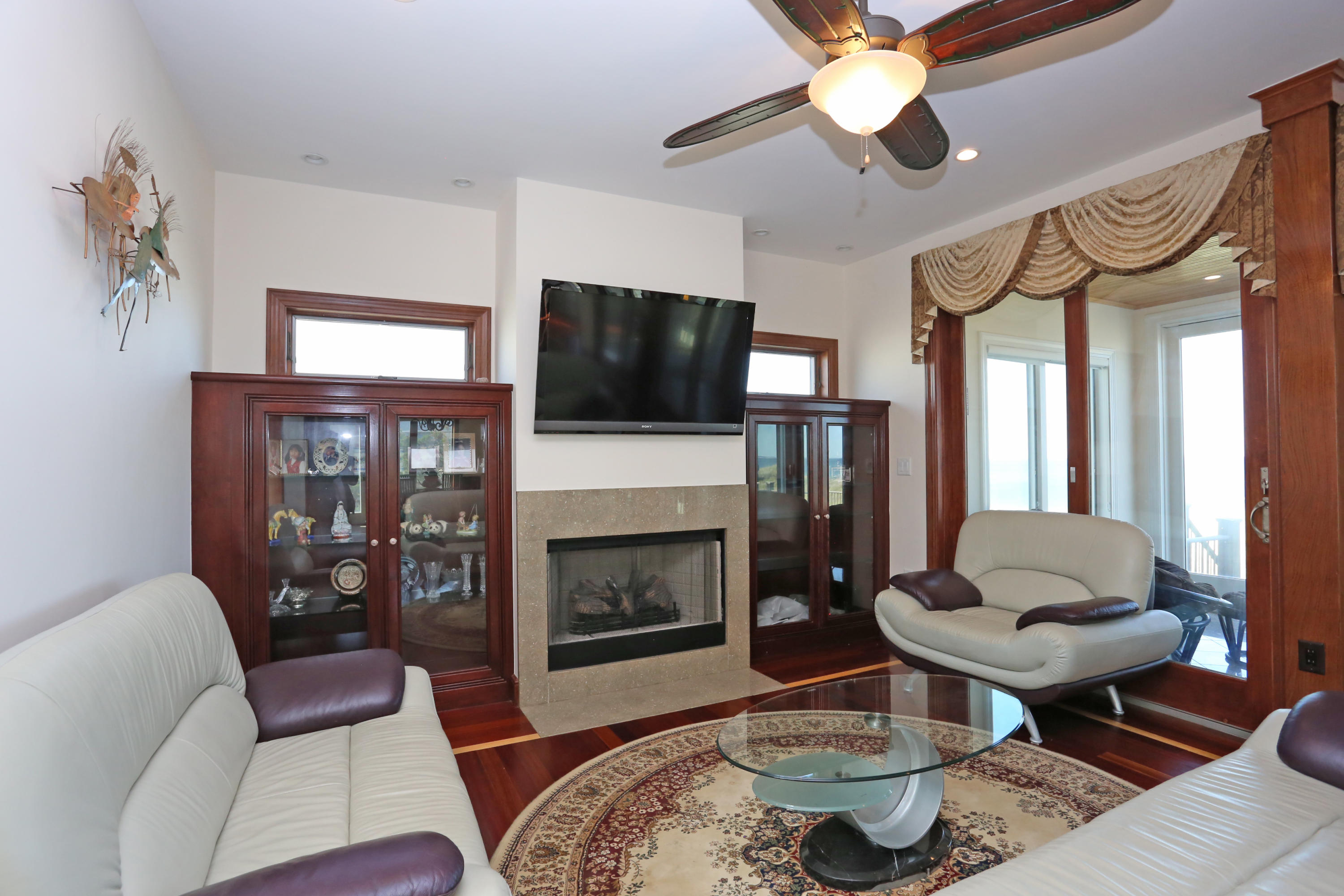 99 Phillips Road Sagamore Beach, MA 02562 - Photo 20 of 30 a living room with furniture a flat screen tv and a fireplace