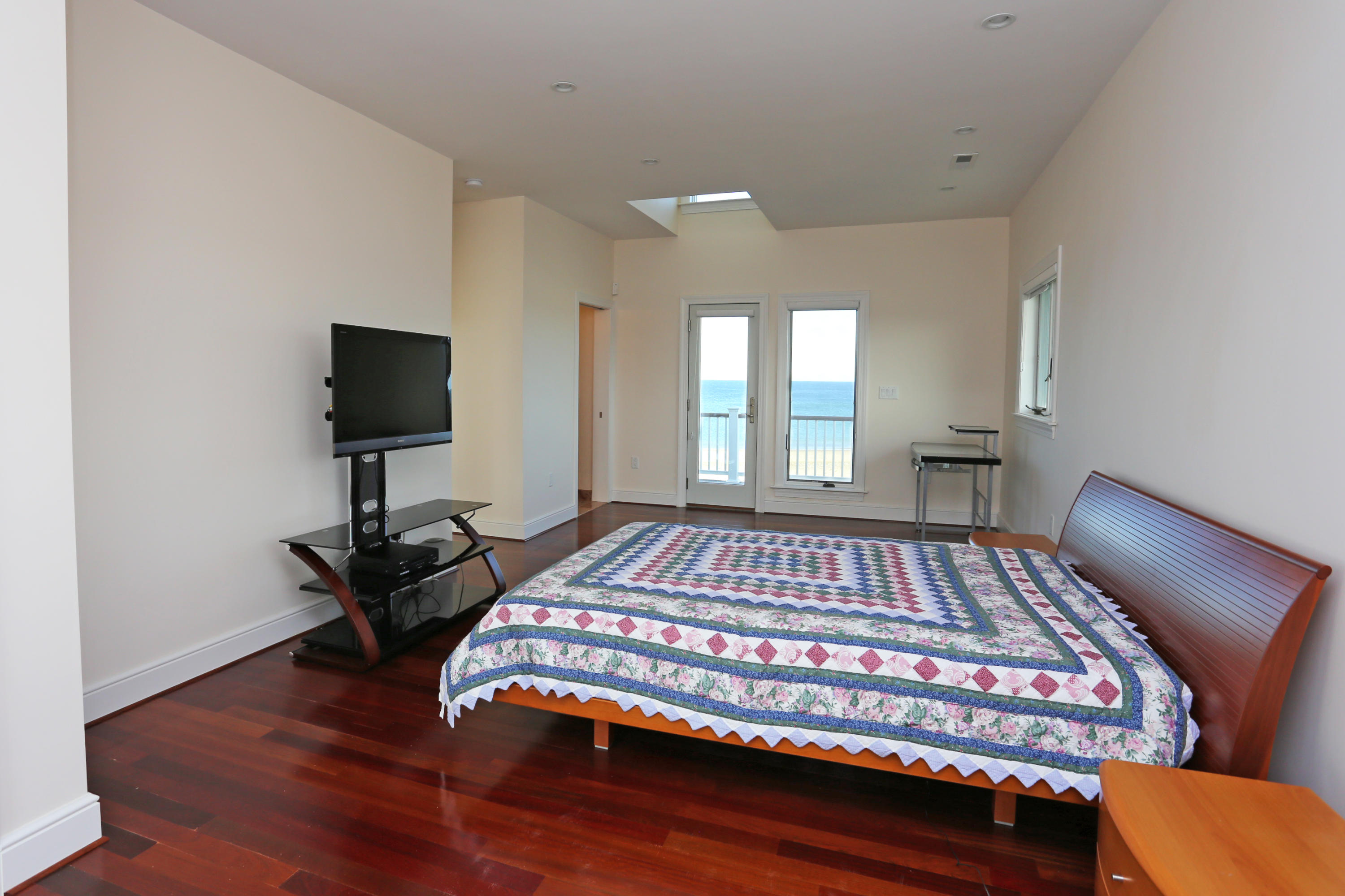 99 Phillips Road Sagamore Beach, MA 02562 - Photo 25 of 30 a bedroom with a bed and wooden floor