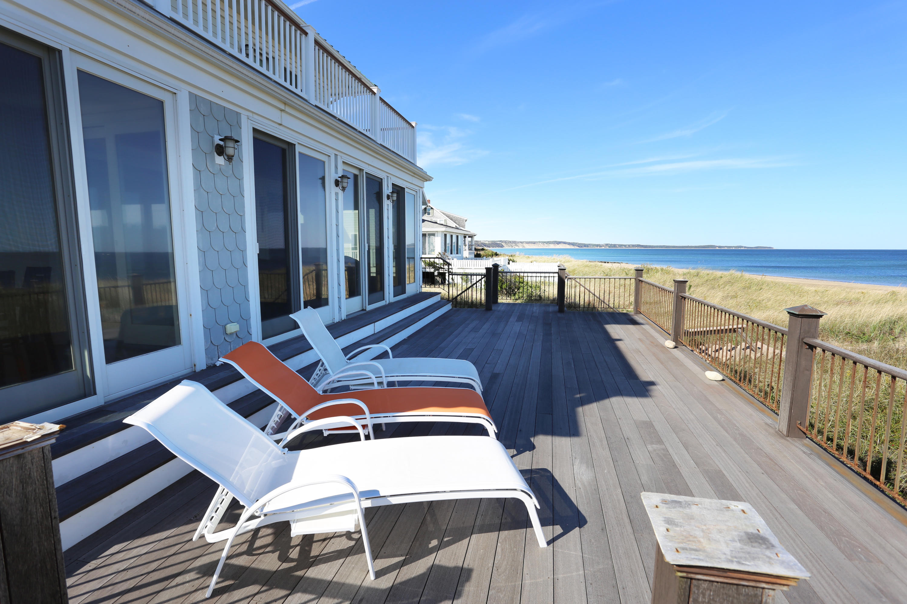 99 Phillips Road Sagamore Beach, MA 02562 - Photo 8 of 30 a view of a balcony with wooden floor and outdoor seating