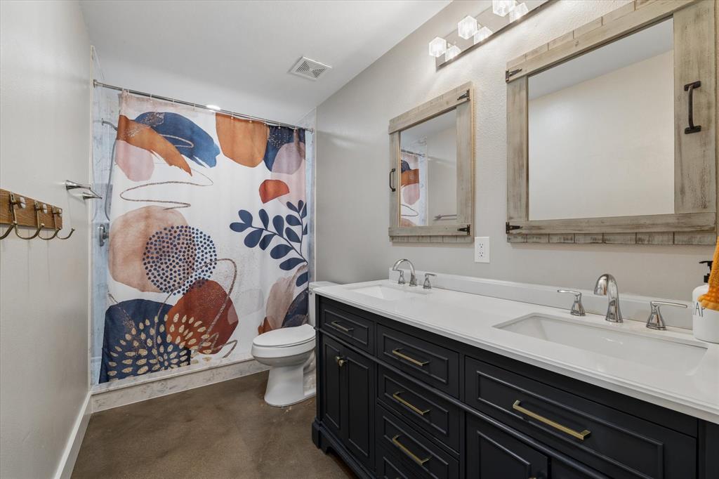 286 Benevolence Way China Spring, TX 76633 - Photo 22 of 37 Double vanity with white countertop, chrome fixtures, and dark wood cabinetry