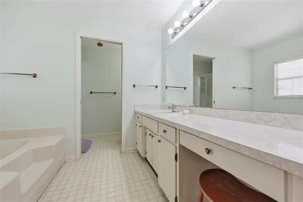 a spacious bathroom with a granite countertop sink mirror and bathtub